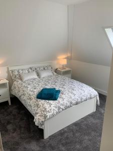 a bedroom with a white bed with a blue towel on it at Ormasaig, Self Catering, One Mile to Town & close to Ben Nevis in Fort William