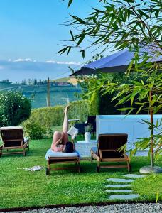 Eine Frau auf einem Stuhl im Gras in der Unterkunft MiaClara Relais in Alba