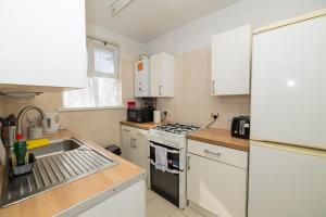 a kitchen with a sink and a stove top oven at Nice Rooms near Shoreditch in London