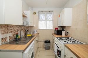 ロンドンにあるNice Rooms near Shoreditchのシンクとコンロのあるキッチン トップオーブン