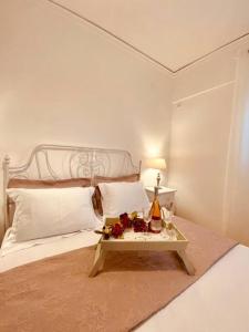 a white bed with a table with a bottle of champagne at Sofi's Home Project in Sitia