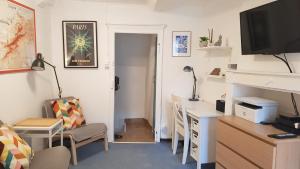 a living room with a desk and a computer and a room at Charming Cottage in a typical French Village in Saint-Christophe-du-Luat