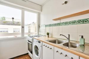 eine Küche mit einer Spüle und einer Waschmaschine in der Unterkunft Appartement Quartier Bastille in Paris