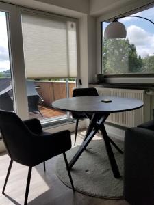 a table and chairs in a living room with a window at Ferienwohnung Wiehl Sonnenterrasse in Wiehl