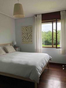 um quarto com uma cama grande e uma janela em Perfect Chalet for Beach Lovers and Golfers em Somo