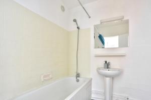 ein Badezimmer mit einer weißen Badewanne und einem Waschbecken in der Unterkunft Appartement Quartier Bastille in Paris
