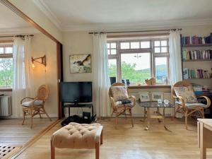 Il comprend un salon doté d'une télévision, de chaises et d'une table. dans l'établissement Bolig i Vatnsoyrar tæt ved lufthavnen, à Vatnsoyrar