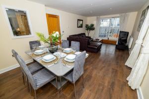 a living room with a dining room table and chairs at Two bed Apartment near Canary Wharf in London