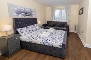 um quarto com uma cama e um sofá em Two bed Apartment near Canary Wharf em Londres