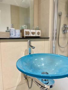 ein blaues Waschbecken im Bad mit Dusche in der Unterkunft Stylish 2 Bed/Bath Apartment in Birmingham