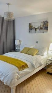 a bedroom with a large white bed with a yellow blanket at Stylish 2 Bed/Bath Apartment in Birmingham
