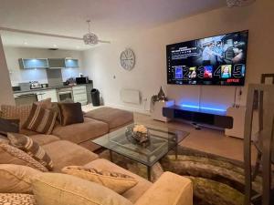 ein Wohnzimmer mit einem Sofa und einem Flachbild-TV in der Unterkunft Stylish 2 Bed/Bath Apartment in Birmingham