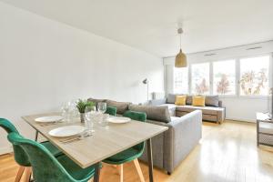 ein Wohnzimmer mit einem Tisch und einem Sofa in der Unterkunft Appartement Quartier Bastille in Paris