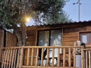 una cabina con una recinzione in legno e un albero di maison du olival 