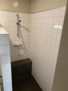 um chuveiro numa casa de banho em azulejos brancos com piso preto em Hof Gensterbloem 