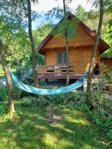 a hammock in front of a log cabin at Pure Nature in Bihać