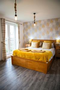 a bedroom with a large bed with a yellow blanket at Sandy Bottom in Filey