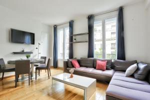 ein Wohnzimmer mit einem Sofa und einem Tisch in der Unterkunft Appartement Quartier Champs-Élysées 4 in Paris