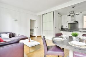 ein Wohnzimmer mit einem Tisch und lila Stühlen in der Unterkunft Appartement Quartier Champs-Élysées 4 in Paris