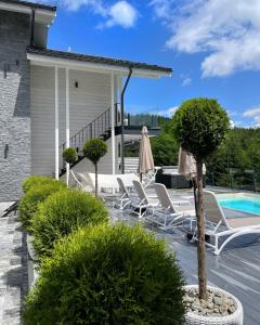 a patio with lounge chairs and a pool at be be Chalet - premium jacuzi & private pool in Bukovel