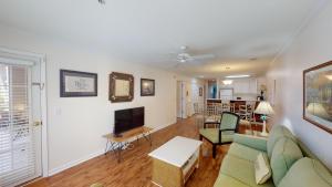 a living room with a couch and a tv at Pawleys Island Fairway Haven 3BR Villa in Pawleys Island