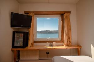 ein Schlafzimmer mit Fenster und Blick aufs Wasser in der Unterkunft Hotel de Castro in Castro