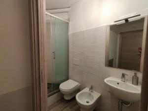 a bathroom with a toilet and a sink and a mirror at B&B il Melograno in Paulilatino