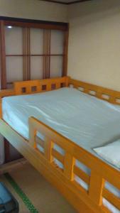 盛岡市にあるFemale Only Dormitory 4beds room- Vacation STAY 14308vのベッドルーム1室(木製ベッド1台、青いシーツ付)