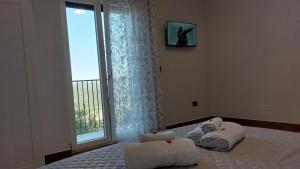 NoepoliにあるNirvana Bed and Breakfast Experienceのベッドルーム1室(タオル付きのベッド1台、窓付)