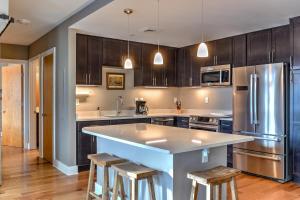 eine Küche mit Holzschränken und eine große Insel mit Barhockern in der Unterkunft 45 Asheland Avenue Unit 505 in Asheville