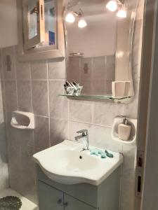 een badkamer met een wastafel en een spiegel bij Aloi Studios in Frilingiánika