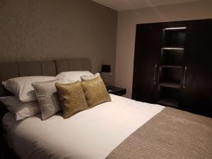 sypialnia z łóżkiem z białą pościelą i poduszkami w obiekcie The Queens Head, Parkside apartment 2 w mieście Burley in Wharfedale