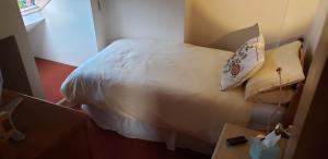 a bedroom with a white bed with a pillow at Weaver's House B and B in Cardiff