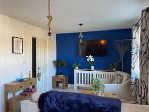 a living room with blue walls and a couch at Sandy Feet in Filey