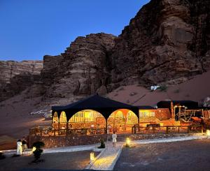 a tent in front of a mountain at night at Desert Magic Camp & Resort in Wadi Rum