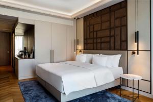 een slaapkamer met een groot wit bed en een tafel bij Radisson Collection Hotel, Magdalena Plaza Sevilla in Sevilla