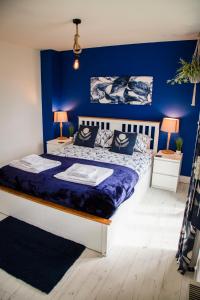 ein Schlafzimmer mit blauen Wänden und einem großen Bett in der Unterkunft Sandy Feet in Filey