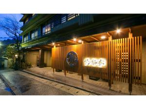 een gebouw waar 's nachts een bord voor staat bij Unazuki Onsen Sanyanagitei - Vacation STAY 06553v in Kurobe