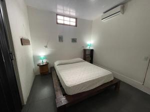 ein Schlafzimmer mit einem Bett und zwei Lampen an zwei Tischen in der Unterkunft Casa Tuanis, Drake Bay in Drake