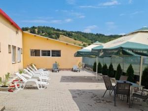 a patio with chairs and tables and umbrellas at Spa Clisura Dunarii in Eşelniţa