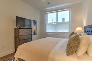 a bedroom with a bed and a flat screen tv at 55 South Market Condo 216 in Asheville