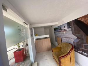 Apartahotel Saroa في Fonseca: غرفة معيشة بها كرسي وجدار