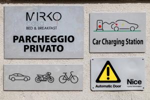 un grupo de signos a un lado de una pared en Casa Mirko - B & B con stazione ricarica auto elettriche parcheggio privato auto moto biciclette en Arezzo