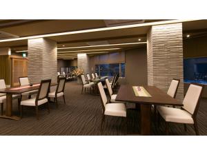 une salle à manger avec des tables et des chaises blanches dans l'établissement Unazuki Onsen Sanyanagitei - Vacation STAY 06440v, à Kurobe