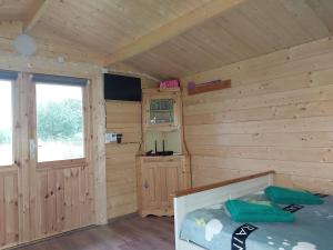 a room with a bed in a wooden cabin at Treimani Meremaja in Treimani