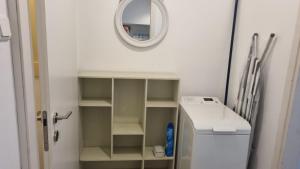 a small bathroom with a mirror and a white refrigerator at Stylish Quiet and Central in Rechovot