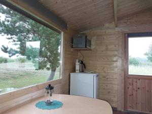 a kitchen with a table and a window and a refrigerator at Treimani Meremaja in Treimani