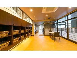 um quarto com mesa, cadeiras e prateleiras em Unazuki Onsen Sanyanagitei - Vacation STAY 06522v em Kurobe