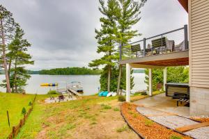 a house with a deck and a view of the water at Modern Traverse City Lake House with Hot Tub! in Traverse City
