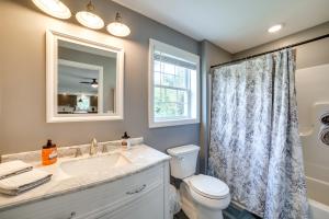 La salle de bains est pourvue d'un lavabo, de toilettes et d'un miroir. dans l'établissement Fombell Home with Private Deck 36 Mi to Pittsburgh, 